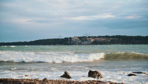 Video - Waves rolling onto a rocky shoreline with Ile Sainte Marguerite visible in the distance