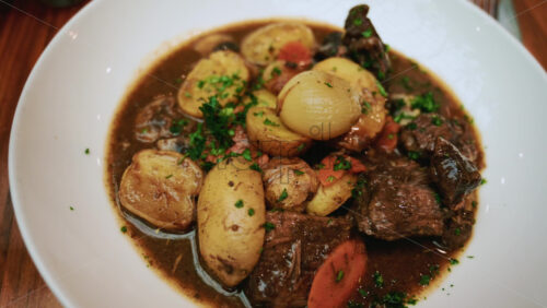 Video - A plated dish of slow cooked beef stew served in a rich brown sauce