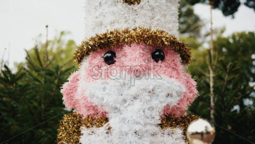 Video - Decorative Christmas nutcracker soldier figure displayed outdoors with trees in the background