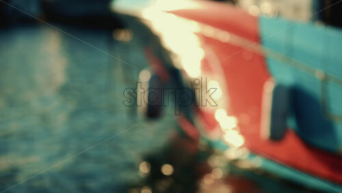 Video - Close up of colorful reflections from a boat hull rippling across the water surface