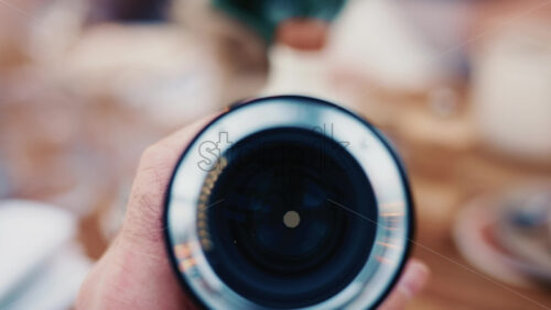 Video - Close up of a camera lens held in hand with soft background bokeh