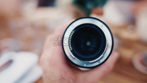 Video - Close up of a camera lens held in hand with soft background bokeh