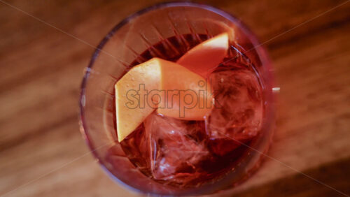 Video - Overhead shot of a cocktail glass containing ice and citrus slices