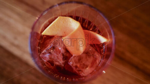 Video - Overhead shot of a cocktail glass containing ice and citrus slices