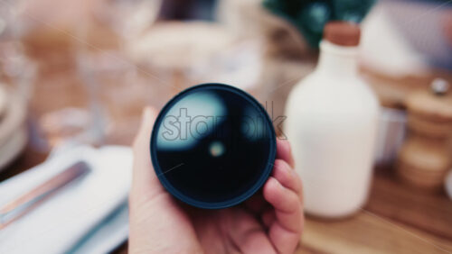 Video - Close up of a camera lens held in hand with soft background bokeh