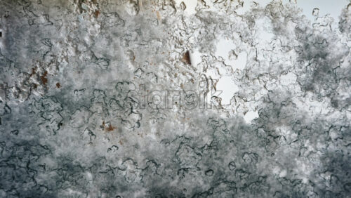 Video - Close up view of an icy or frosted surface with fine texture and soft blue tones