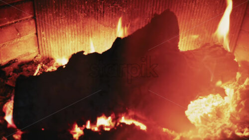 Video - Burning firewood inside a fireplace with glowing embers and warm flames