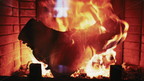 Video - Burning firewood inside a fireplace with glowing embers and warm flames