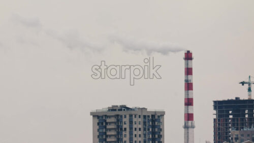 Video - Urban skyline with residential buildings and an industrial chimney emitting smoke