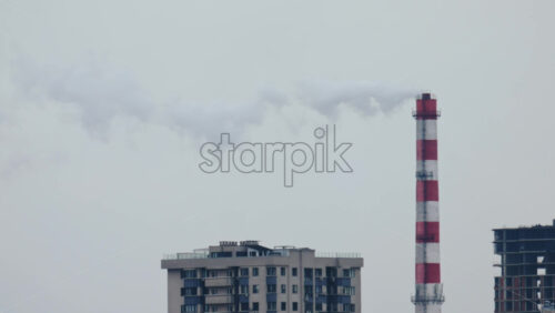 Video - Urban skyline with residential buildings and an industrial chimney emitting smoke