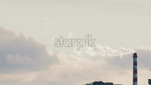 Video - Urban skyline with residential buildings and an industrial chimney emitting smoke