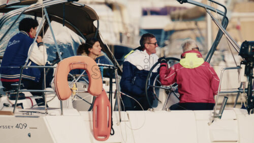 Video – Antibes, France – December 17, 2025: Group of people seated on a sailboat while maneuvering in a marina - Starpik Stock