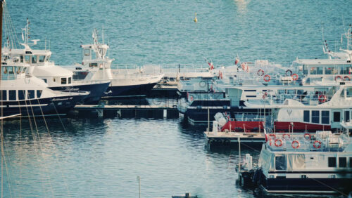 Video – Cannes, France – December 20, 2025: Boats and small vessels docked in a marina with a lighthouse visible in calm blue water - Starpik Stock