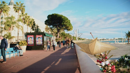 Video – Cannes, France – December 23, 2025: Golden Christmas star decoration attached to a seafront railing along La Croisette - Starpik Stock
