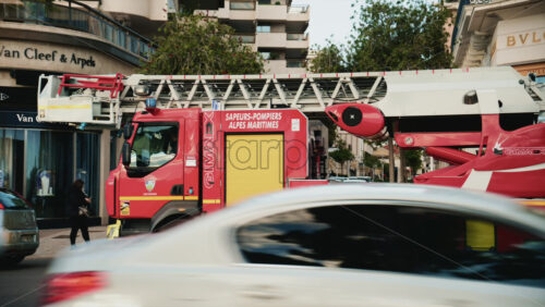 Video – Cannes, France – December 23, 2025: Red fire truck driving along La Croisette with palm trees and pedestrians in the background - Starpik Stock