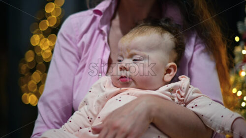 Video – Close up portrait of a baby held by her mother during the Christmas season - Starpik Stock