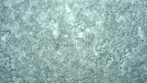 Video – Close up view of an icy or frosted surface with fine texture and soft blue tones - Starpik Stock