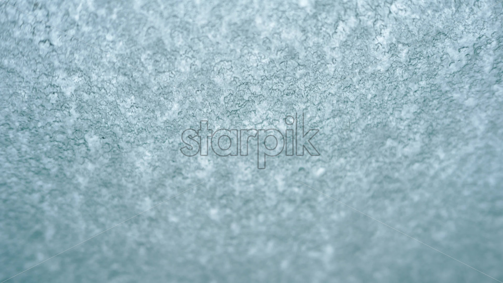 Video – Close up view of an icy or frosted surface with fine texture and soft blue tones - Starpik Stock