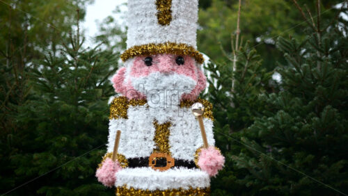 Video – Decorative Christmas nutcracker soldier figure displayed outdoors with trees in the background - Starpik Stock