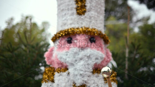 Video – Decorative Christmas nutcracker soldier figure displayed outdoors with trees in the background - Starpik Stock