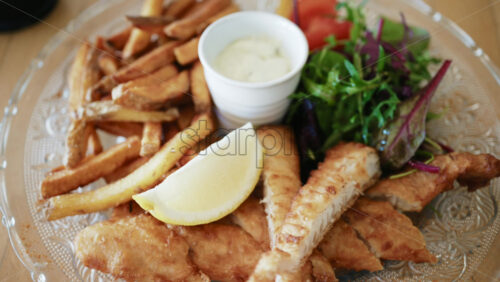 Video – Fish and chips served with crispy fries, fresh salad, lemon wedge, and creamy dipping sauce - Starpik Stock
