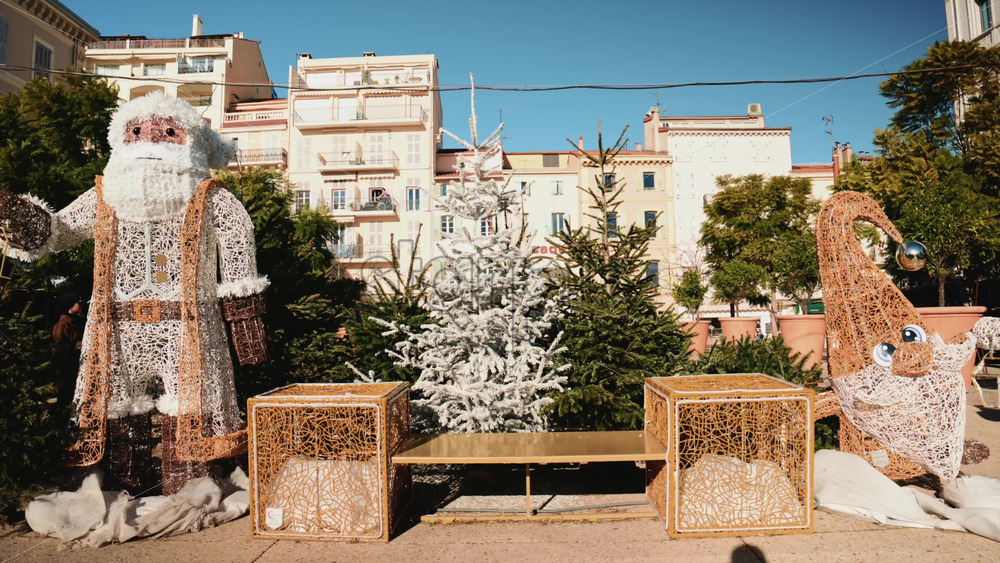 Video – Outdoor Christmas installation featuring large Santa Claus and elf decorations surrounded by fir trees - Starpik Stock