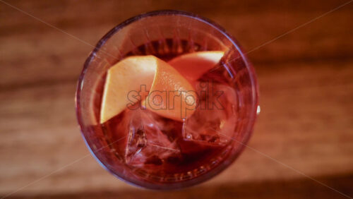 Video – Overhead shot of a cocktail glass containing ice and citrus slices - Starpik Stock