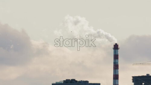Video – Urban skyline with residential buildings and an industrial chimney emitting smoke - Starpik Stock