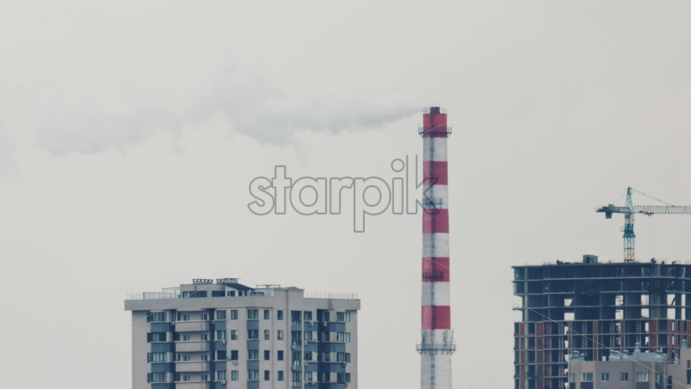 Video – Urban skyline with residential buildings and an industrial chimney emitting smoke - Starpik Stock