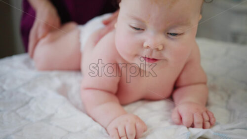 Caregiver holding baby under the chest while the infant balances on arms during tummy time practice