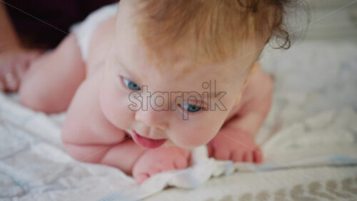 Caregiver holding baby under the chest while the infant balances on arms during tummy time practice