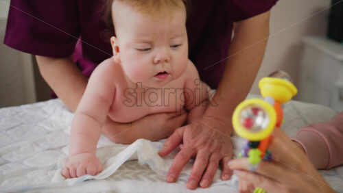 Infant focusing on a bright toy while supported during tummy time