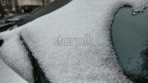Close up of a thick frozen ice layer covering a car surface, showing crystalline texture and compacted frost