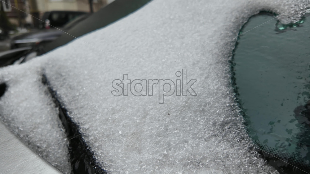 Close up of a thick frozen ice layer covering a car surface, showing crystalline texture and compacted frost