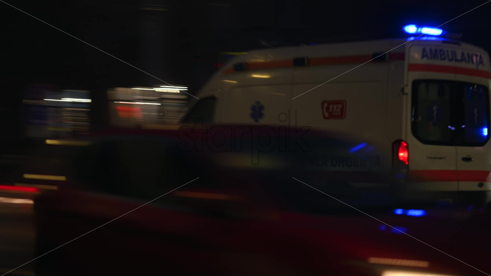 Chisinau, Moldova - January 28, 2026: Urban street at night with moving cars and an ambulance driving through traffic, blue emergency lights flashing
