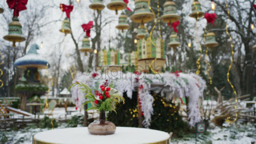 Festive winter decoration with red berries displayed on a table in an outdoor park cafe