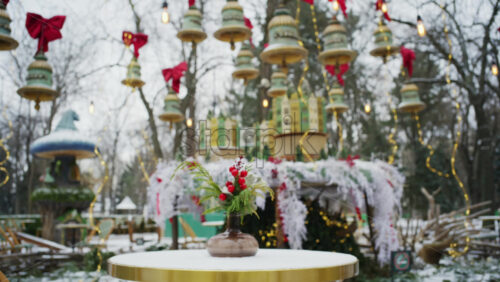 Festive winter decoration with red berries displayed on a table in an outdoor park cafe
