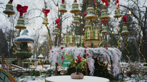 Festive winter decoration with red berries displayed on a table in an outdoor park cafe