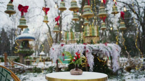 Festive winter decoration with red berries displayed on a table in an outdoor park cafe