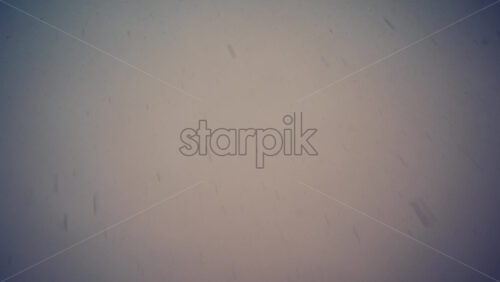 Low angle view of snowflakes falling from the blurry sky