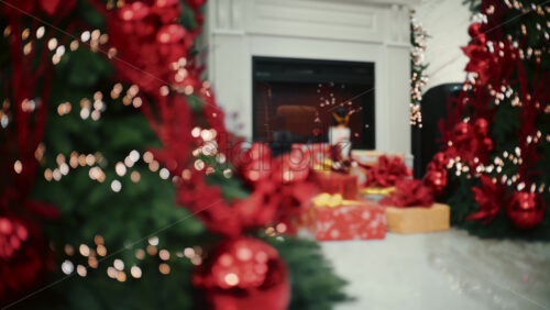 Soft focus view of a Christmas decorated living room with a fireplace, holiday lights, and wrapped gifts