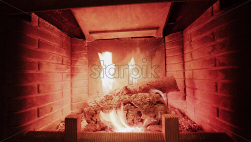 Artistic shot of burning fireplace flames blended with a soft interior reflection, creating a double exposure effect