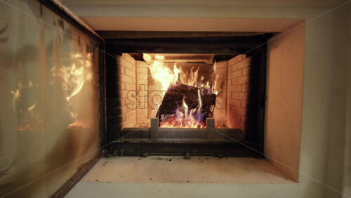 Close up view of a lit fireplace with burning logs and visible flames