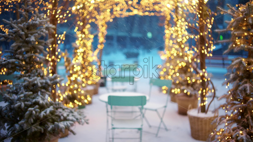Wide view of an outdoor cafe decorated with Christmas lights forming a glowing archway