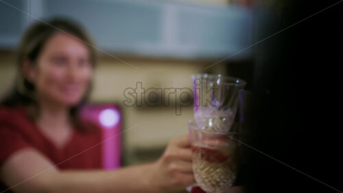 Group of people clinking sparkling wine glasses in a toast during a indoor celebration