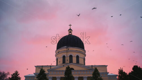 Chisinau, Moldova - January 10, 2026: Exterior view of the Nativity Cathedral topped with a cross against a soft pink and blue sunset sky