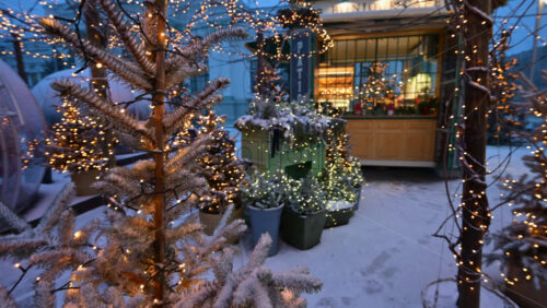 Chisinau, Moldova - January 12, 2026: Wide shot of an outdoor cafe decorated with warm Christmas lights and snow covered trees