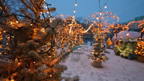 Charming outdoor cafe decorated with Christmas lights, plants, and winter decorations
