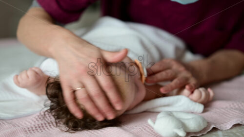 Baby lying calmly on a soft bed after a massage session