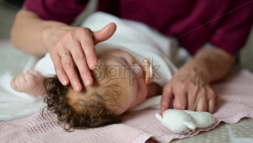 Baby lying calmly on a soft bed after a massage session